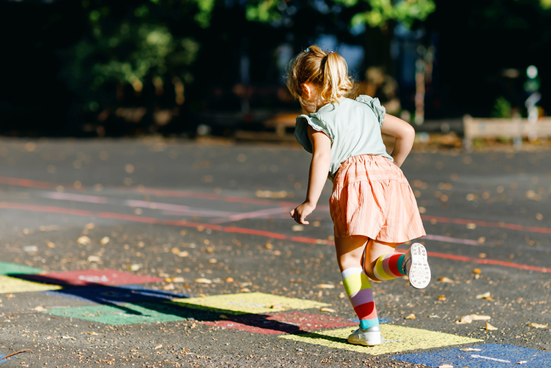 Young kid playing hopscotch