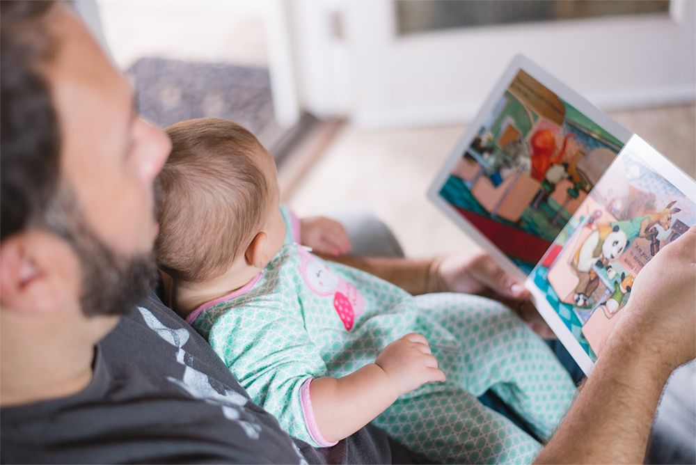 Dad reading to baby for literacy development