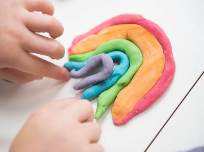 salt dough ornaments that child is making in the shape of a rainbow