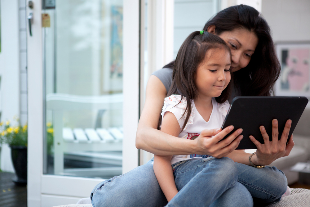 Parent with kid playing with Digital Tablet