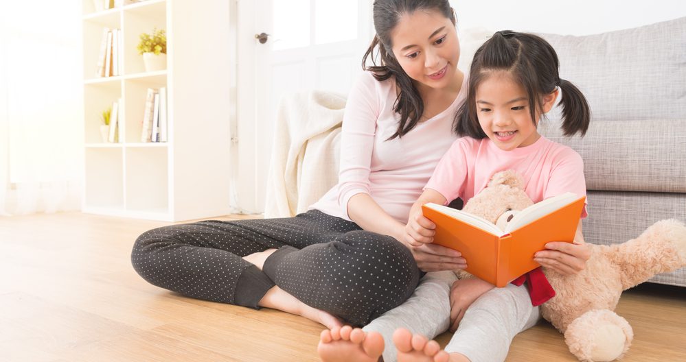 Mom reading on the ground with daughter