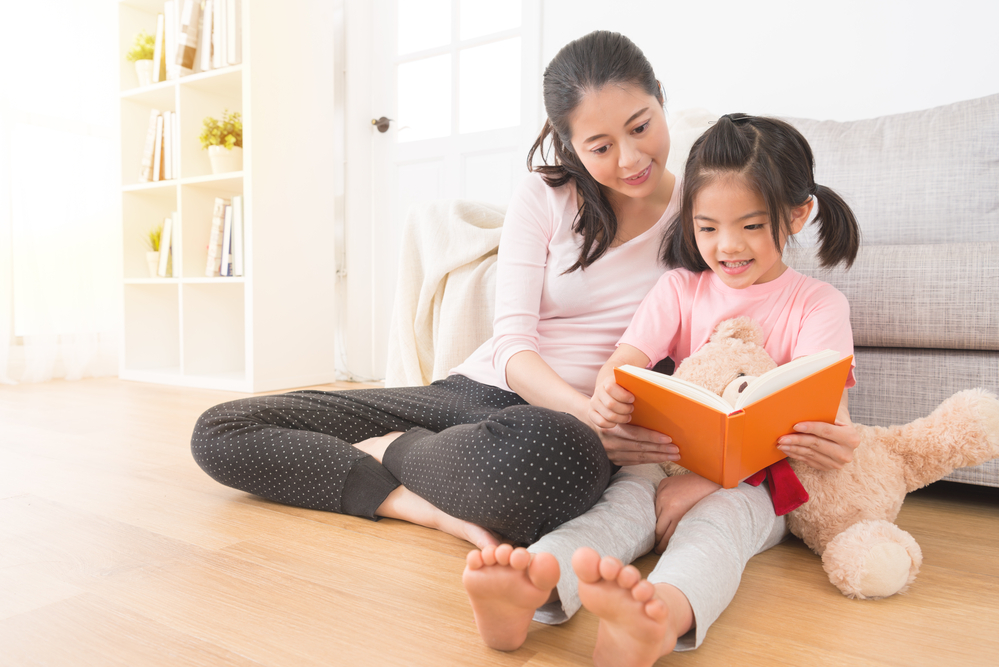 Mom reading on the ground with daughter
