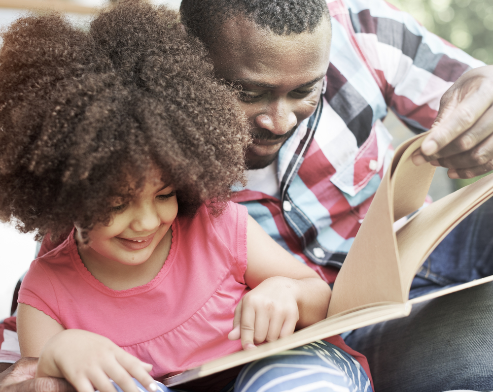 Dad helping daughter read aloud