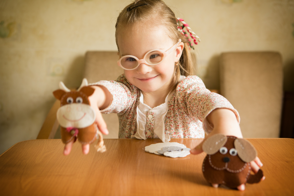 Girl playing with puppet to learn letter-sound correspondence