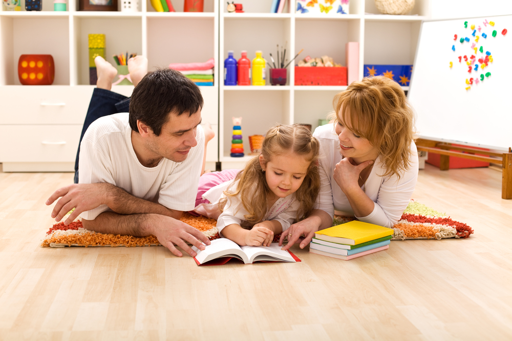 Family on the ground reading together