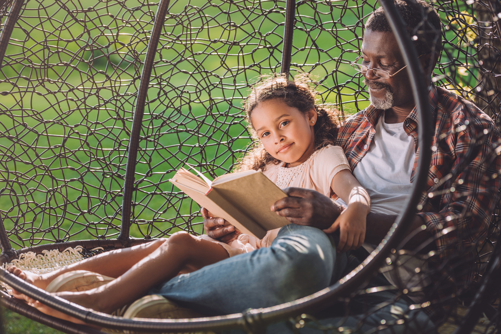 Father and daughter reading in an egg chair