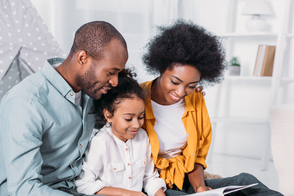 Parents doing shared reading with daughter