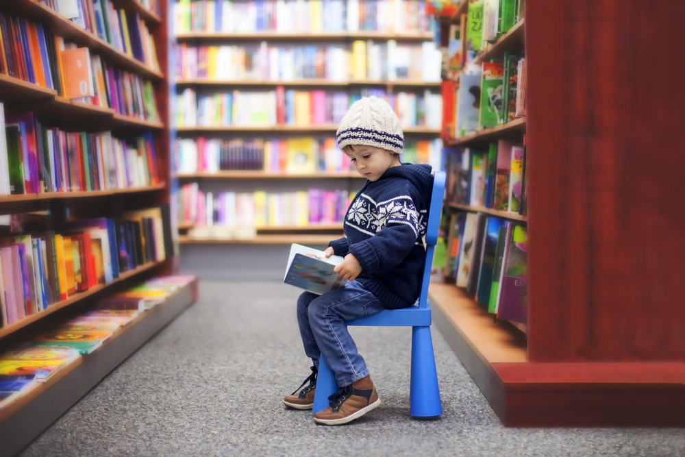 Adorable little boy, sitting in a book store