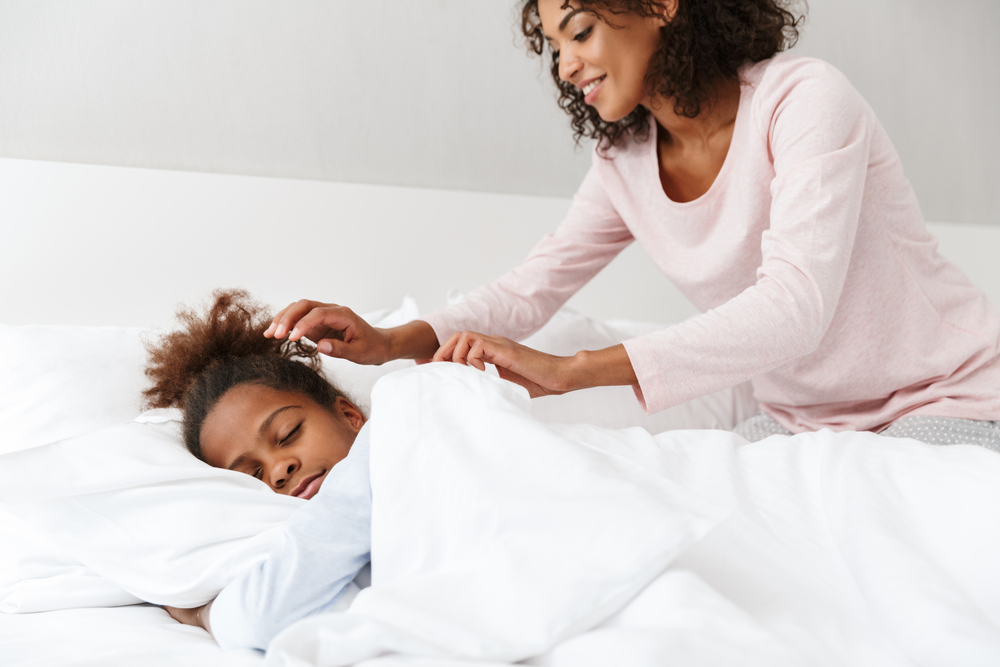 Mom putting daughter to sleep