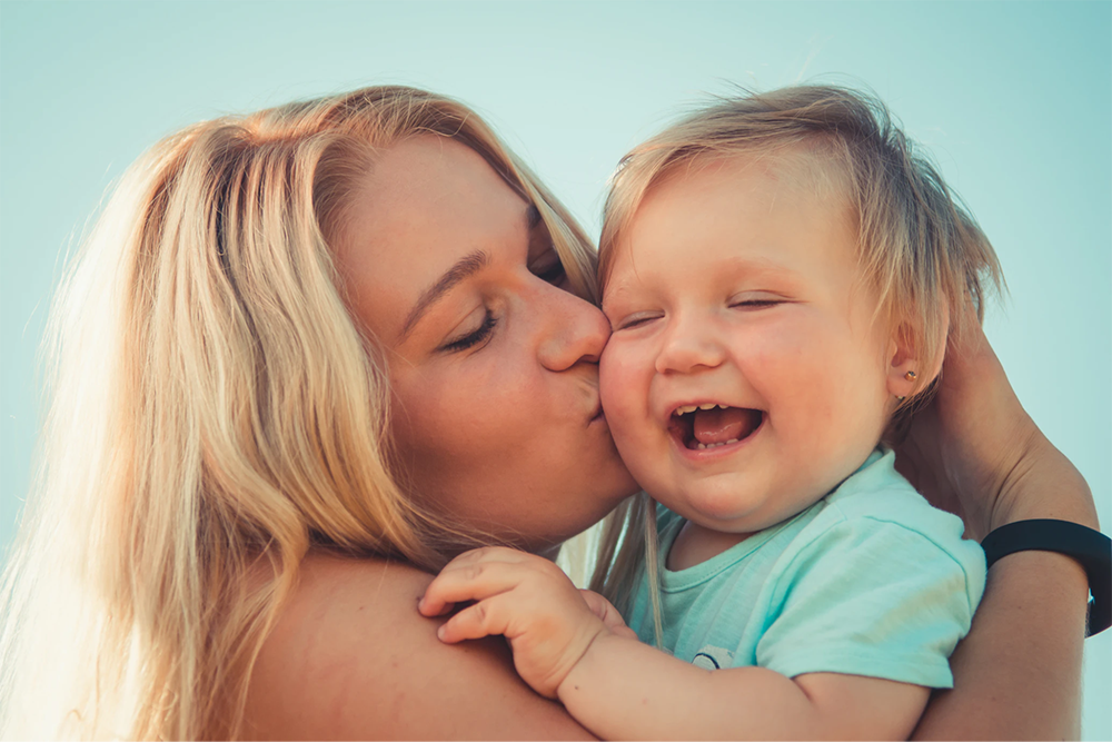 Mom kissing baby on the cheek