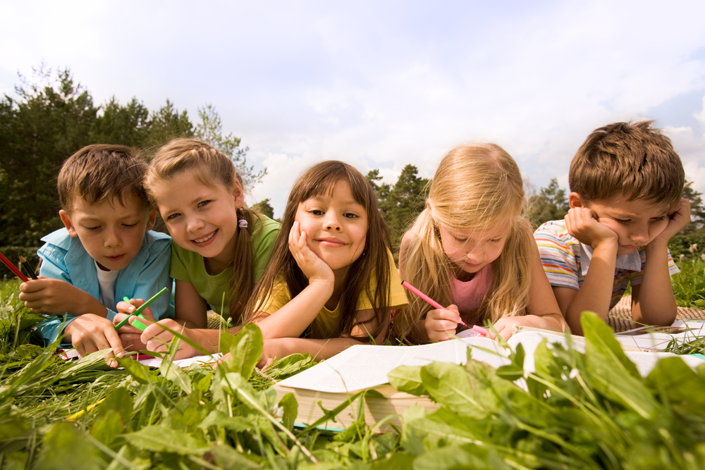 School kids outside working on preschool reading 