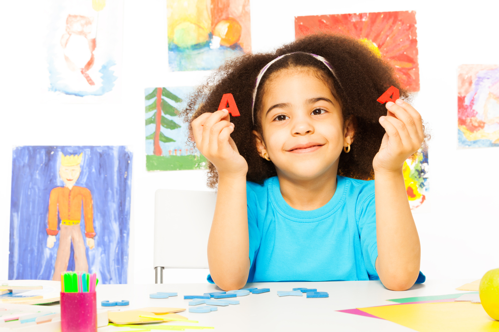 Girl showing letters learning the alphabet