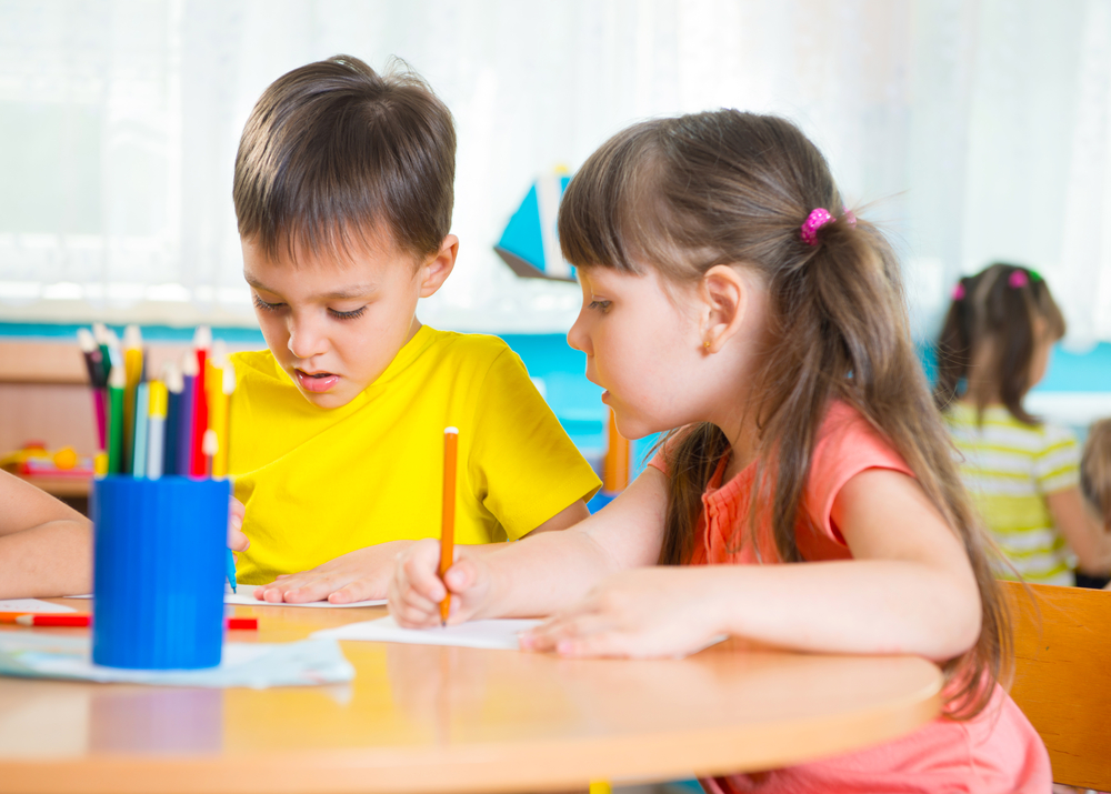 Group of cute little pre-school kids drawing