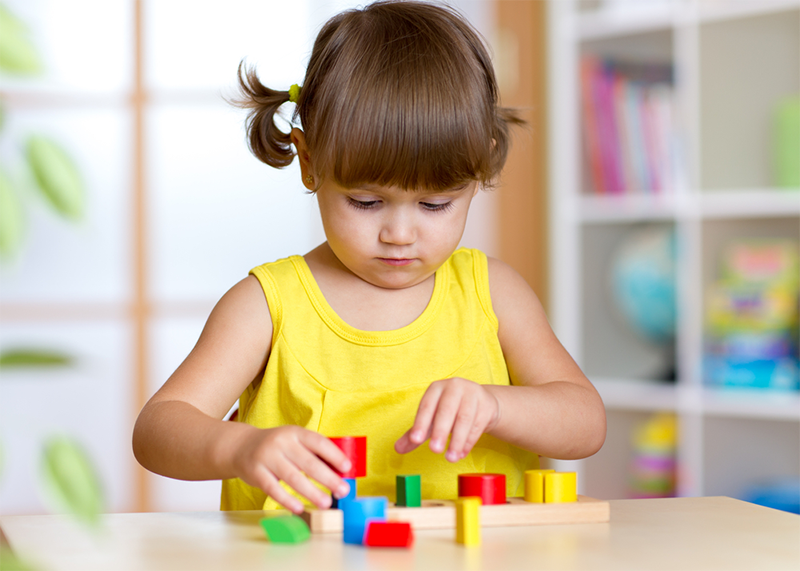 Young girl playing with shapes for kids