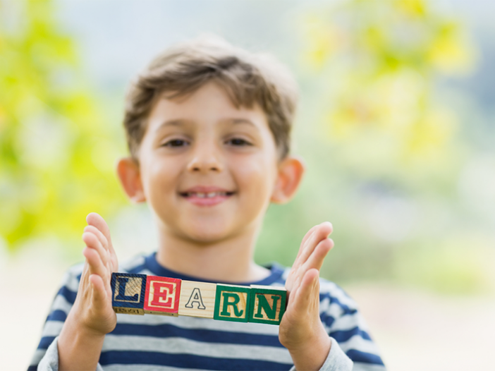 Kid holding blocks that spell his name