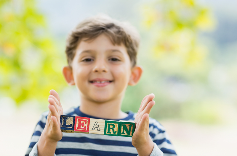 Kid holding blocks that spell his name