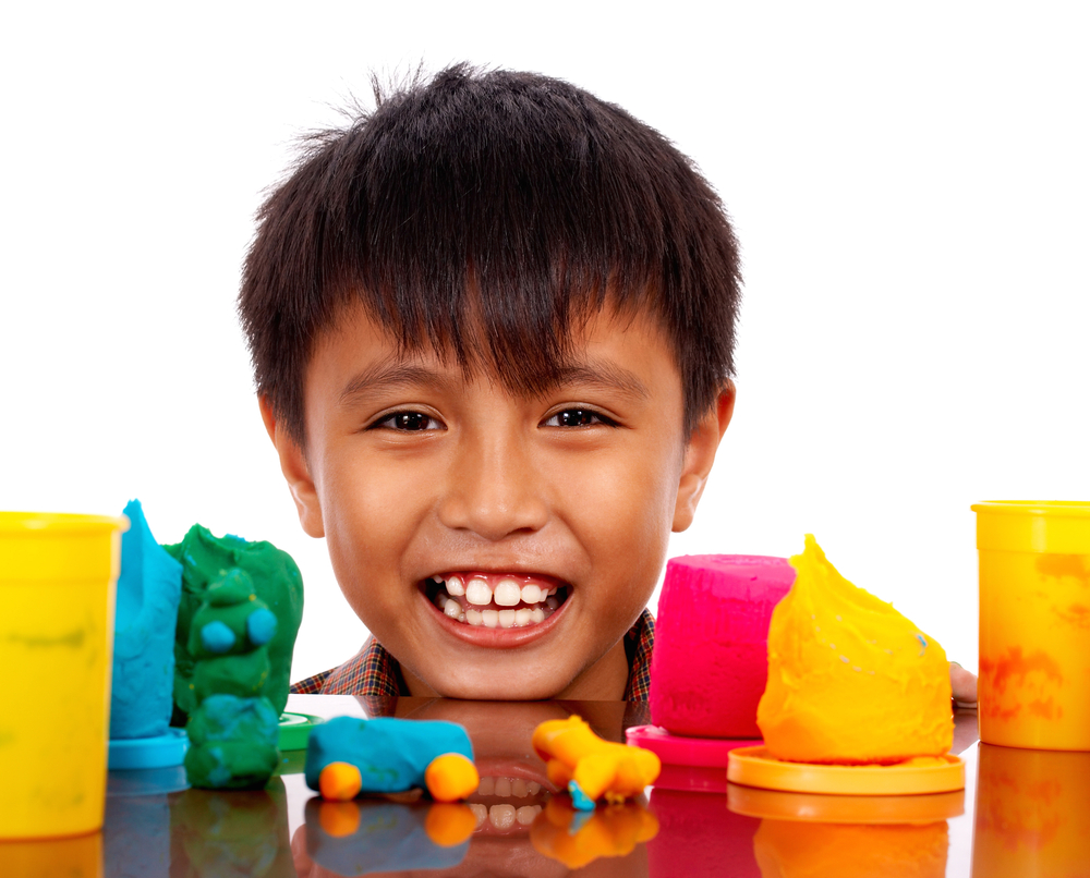 Young kid using play dough for counting activities