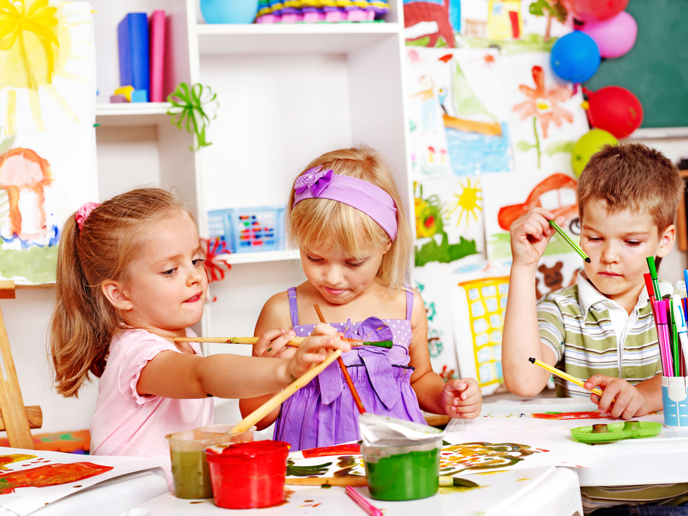 Children painting on an easel.