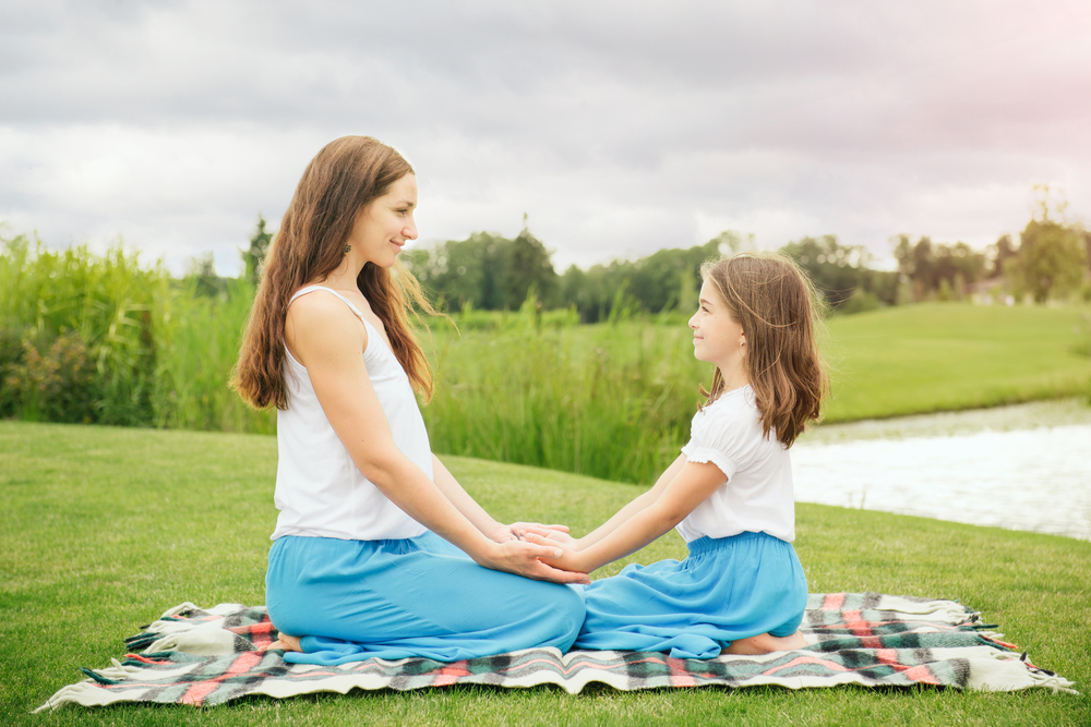 Mother with daughter teacher her meditation for kids