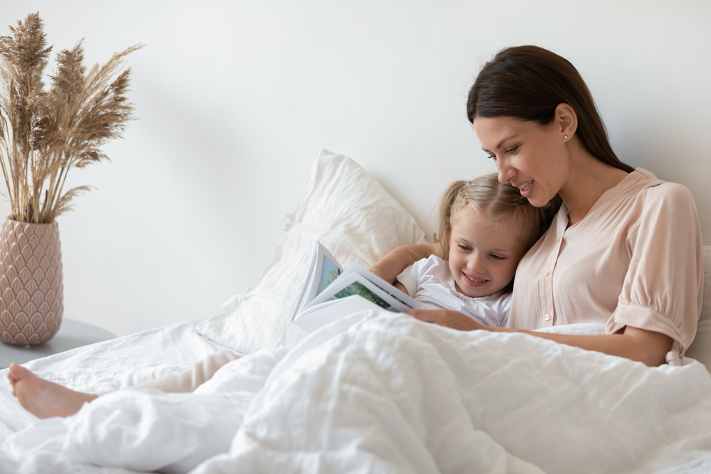 Mom and daughter reading a bed time story together as part of their bedtime routine