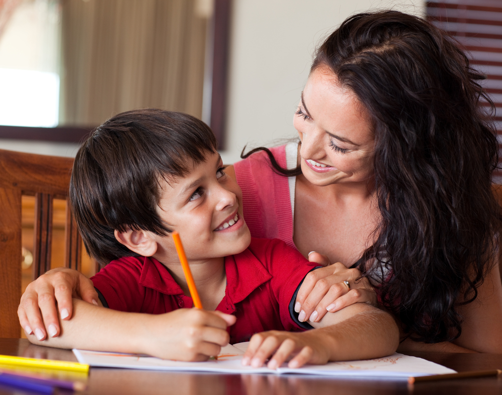 Mom encouraging her son to sound out words when writing them out