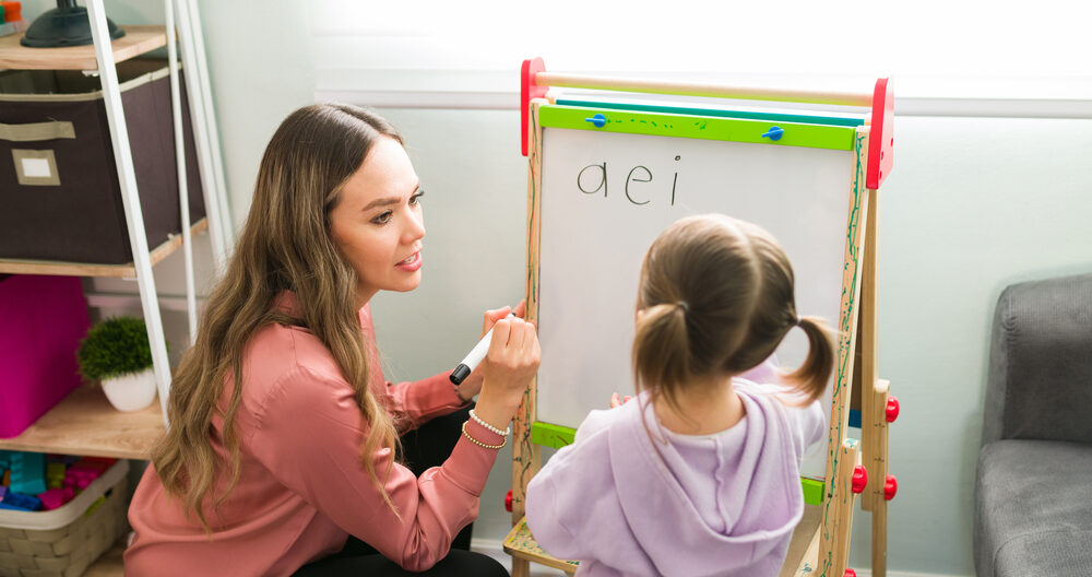 Female teacher teaching vowels to her student