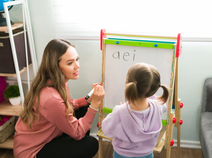 Female teacher teaching vowels to her student