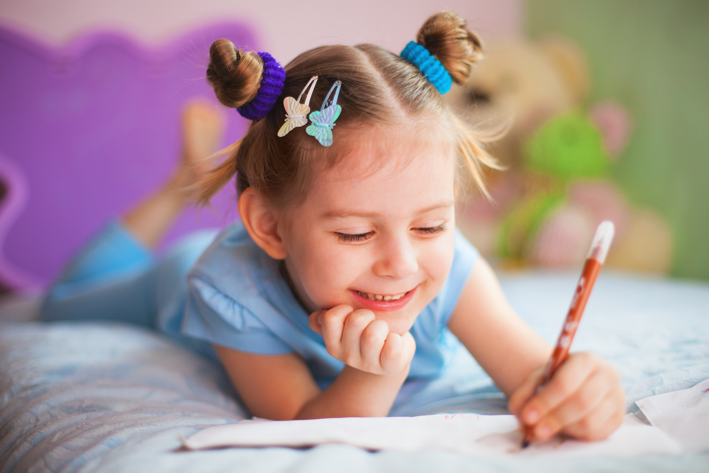 Girl writing a letter on her bed