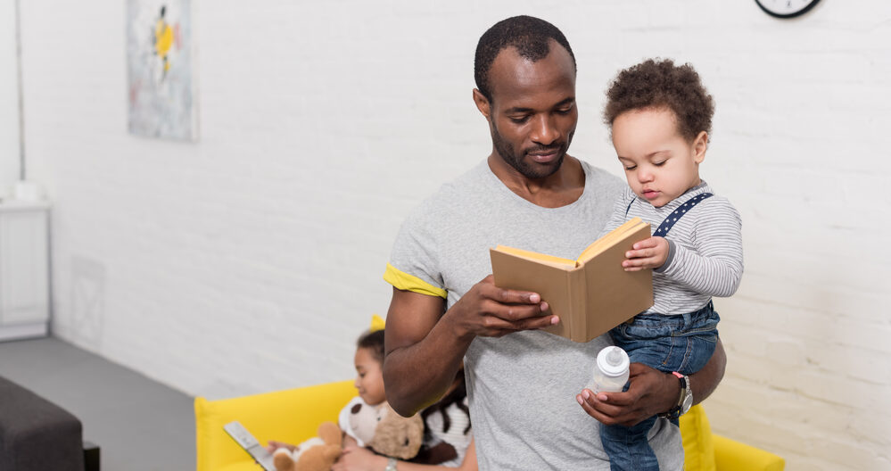 Dad hold child while reading to him