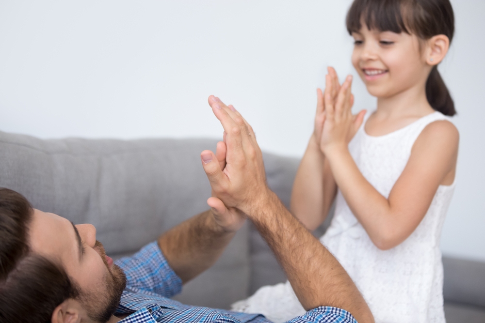 Dad using clapping to teach daughter syllables