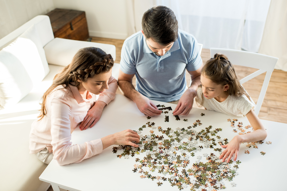 Family working on Cooperative Play by doing a puzzle together