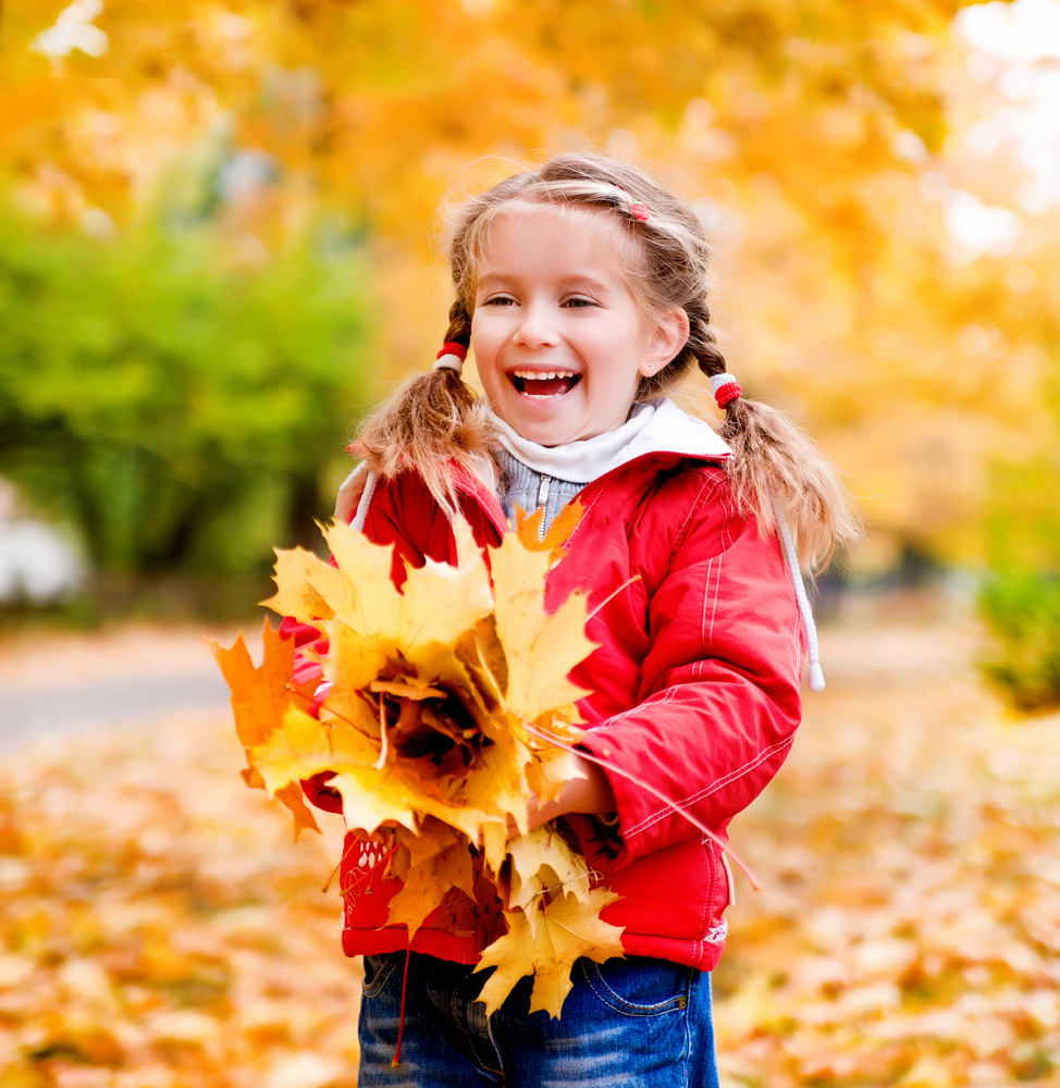 Kid playing leaves in the fall