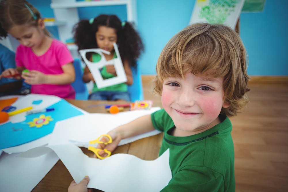 Happy kids doing arts and crafts together at their desk