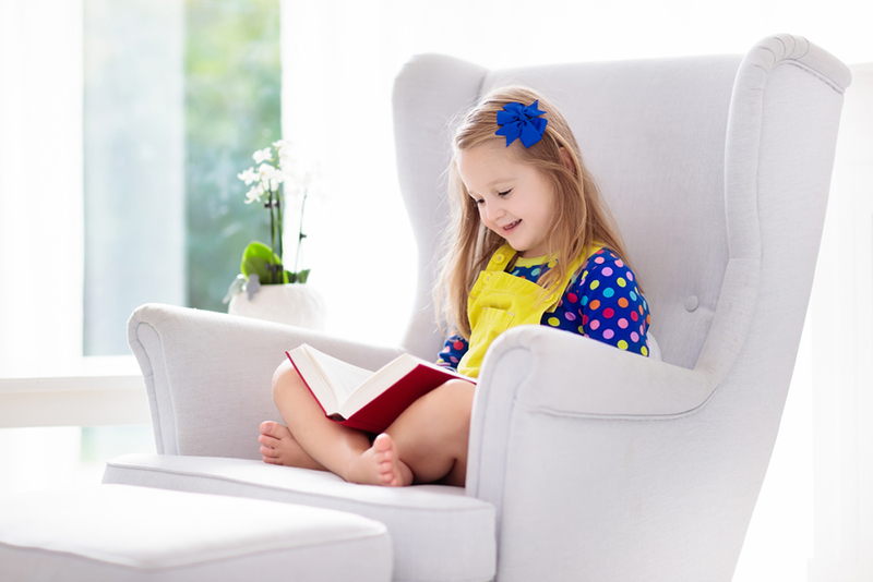 Young kid reading for her kindergarten readiness checklist