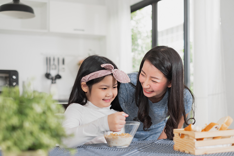 amily happy enjoy having breakfast on table in kitchen