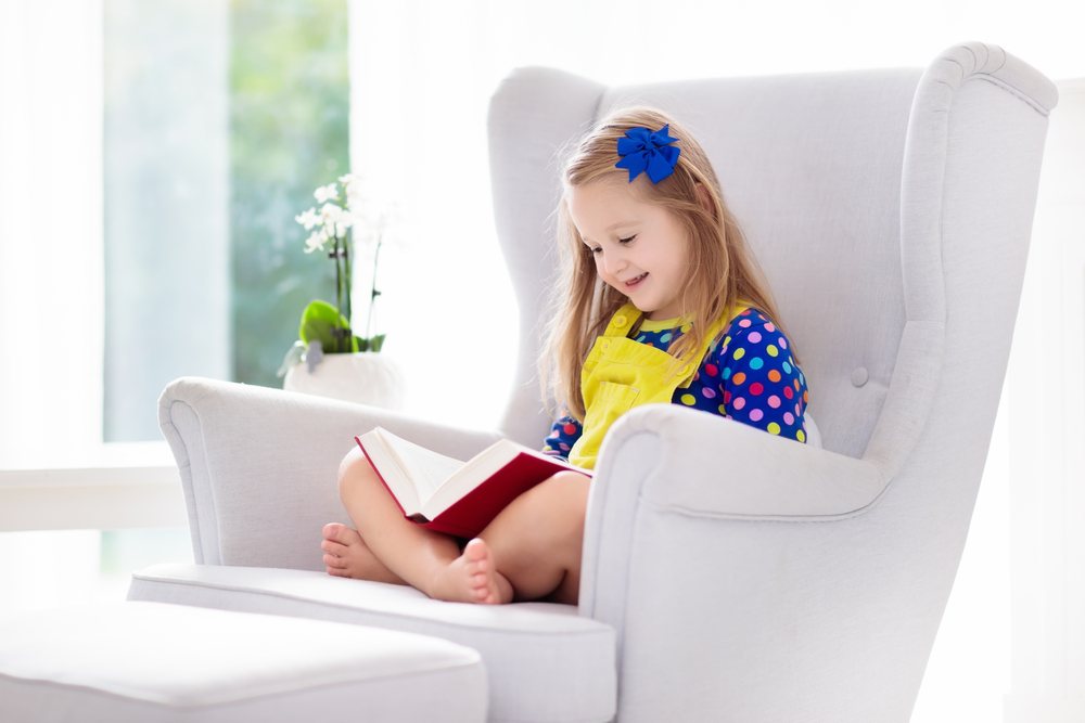 Young girl reading on a chair