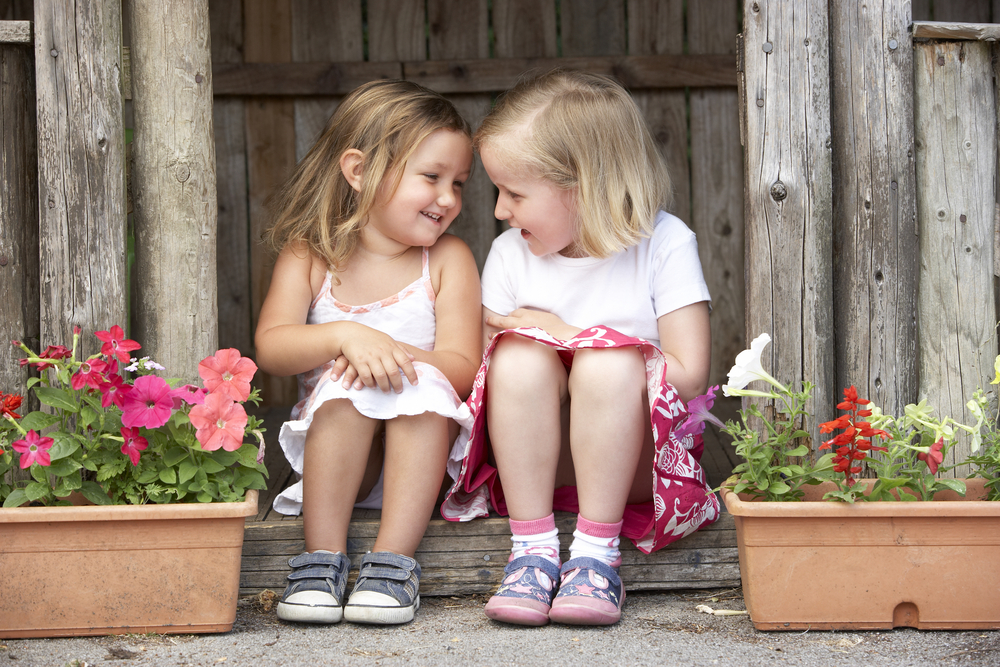 Two Young Girls Playing in Wooden House