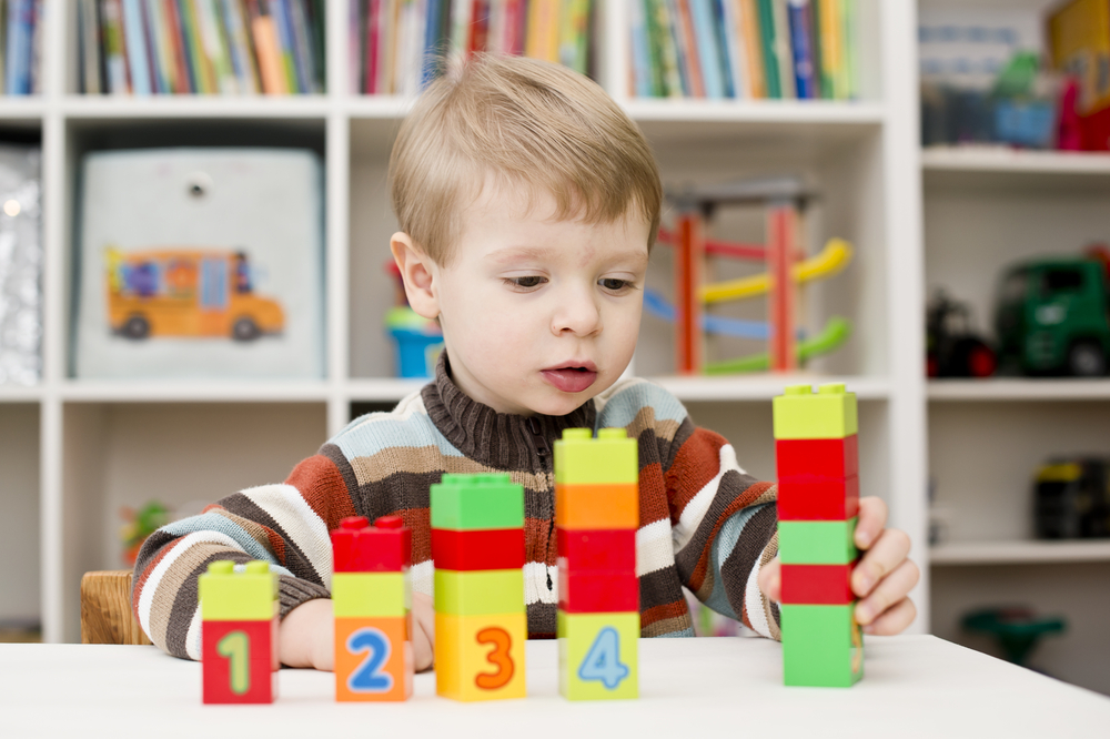 Young boy playing with blocks to learn numbers
