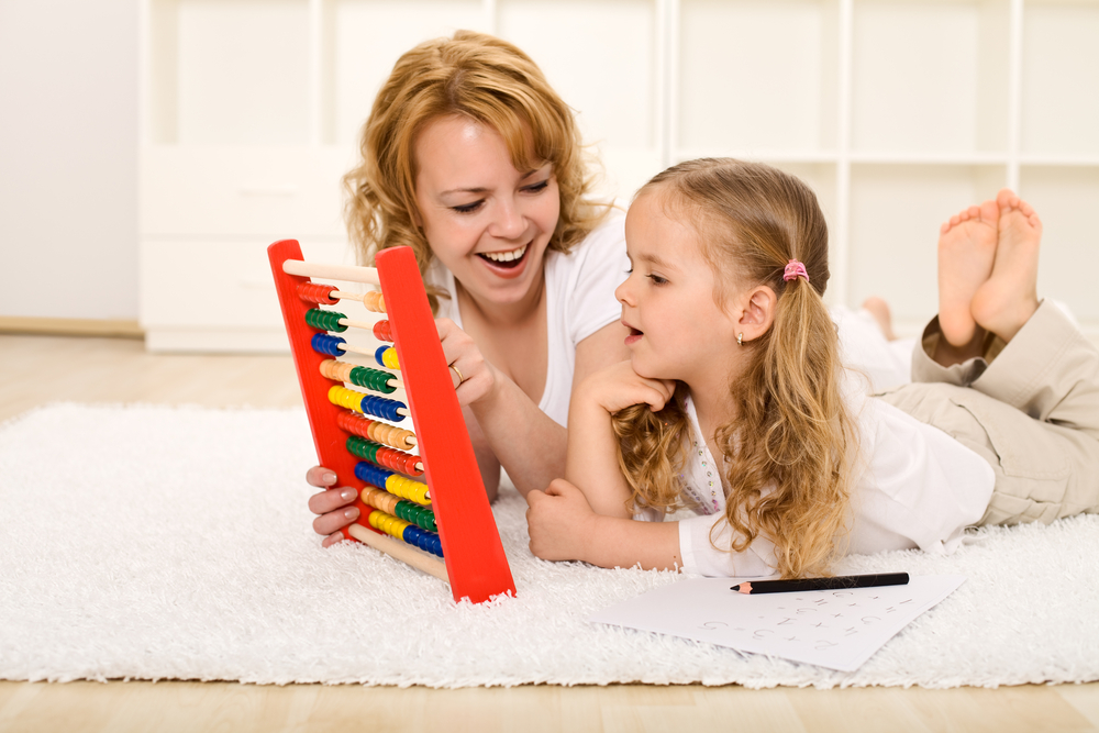 Mom playing with an abacus to teach daughter math