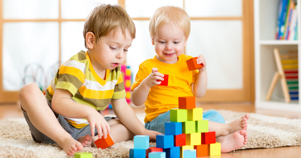 Kids playing block toys in playroom at nursery