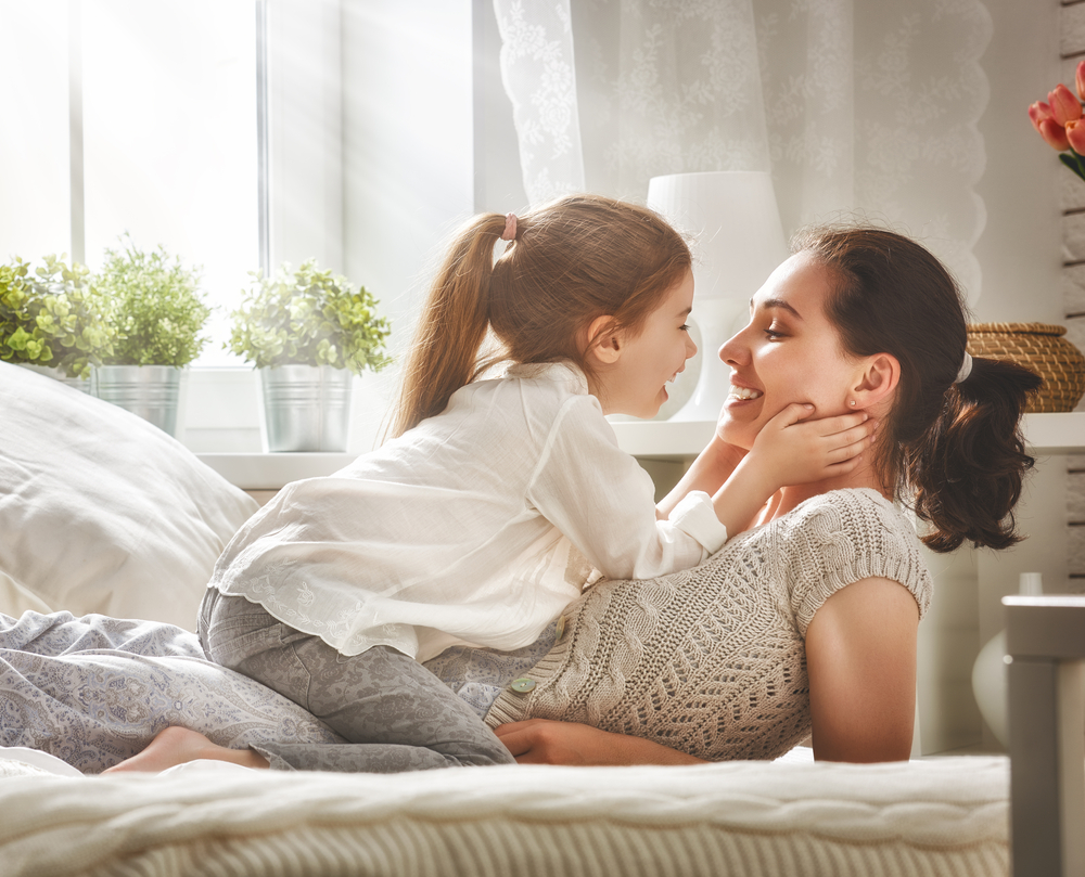 Mother and her daughter child girl playing and hugging.