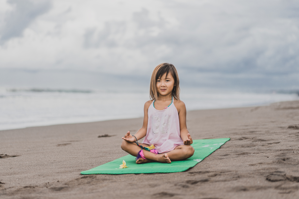 Young girl doing yoga to cope with emotions for kids