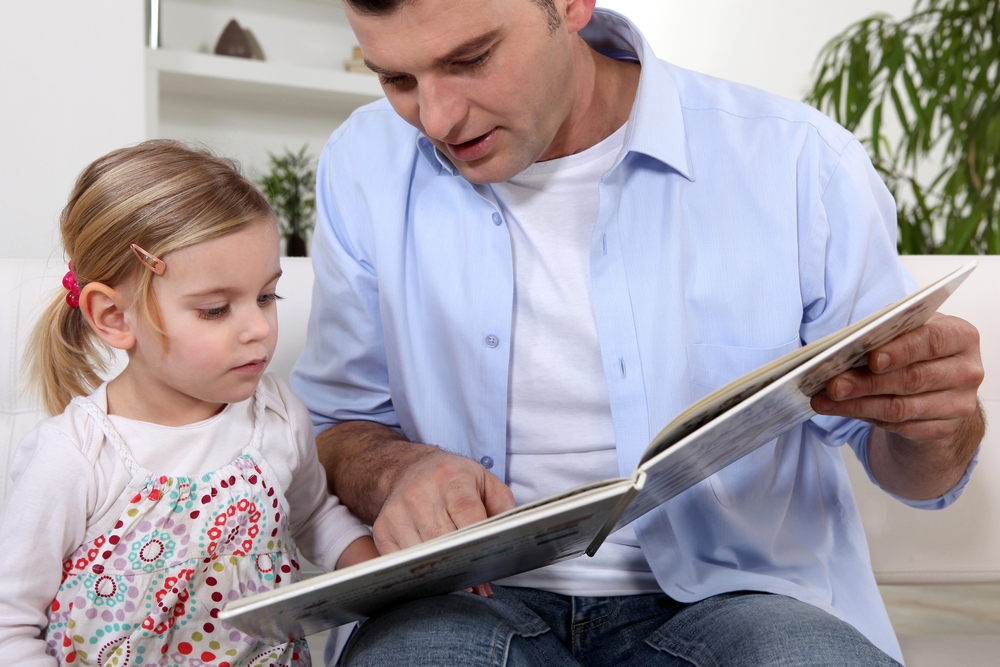 Father reading to his daughter