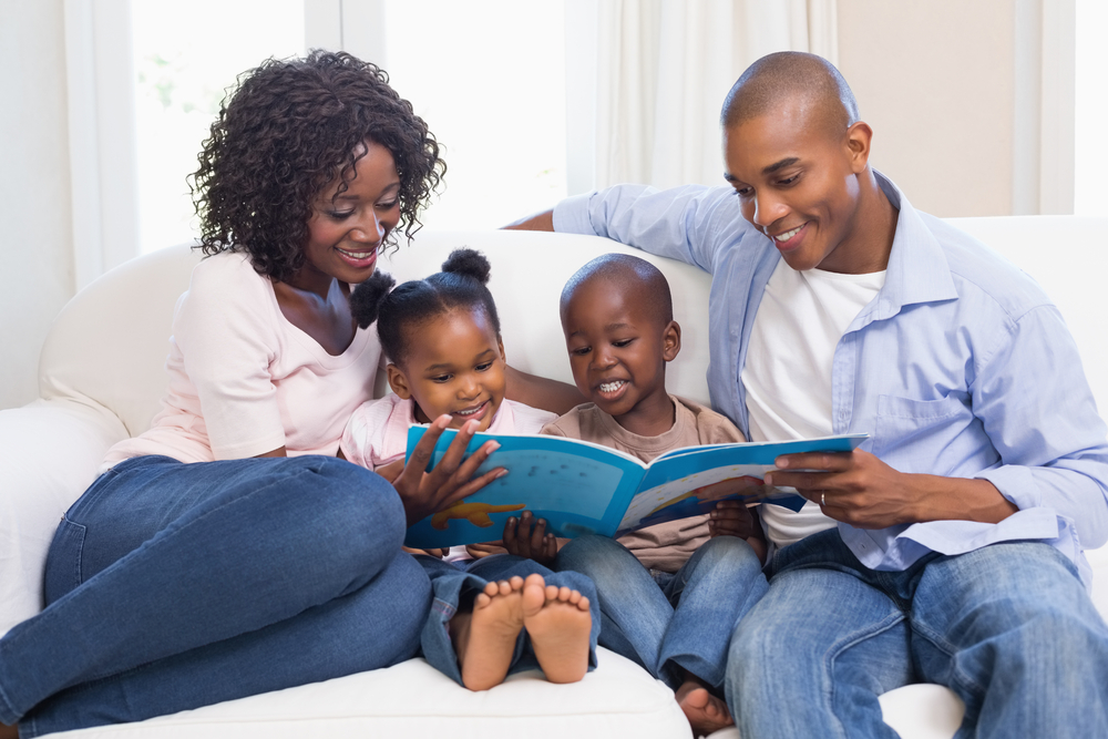 Parents reading with their two kids