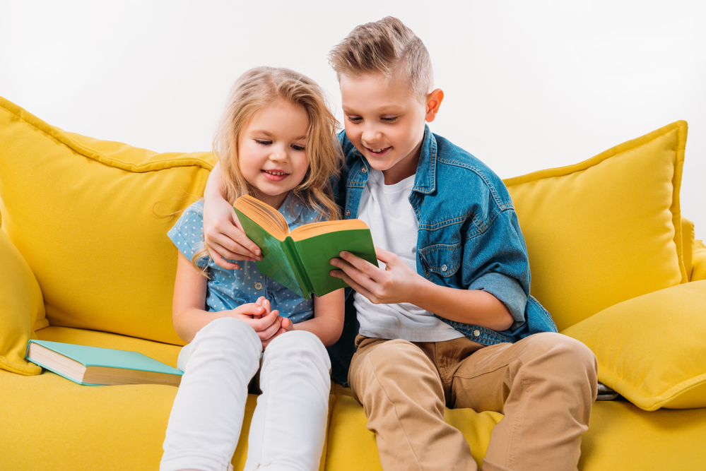 Two kids reading a book together