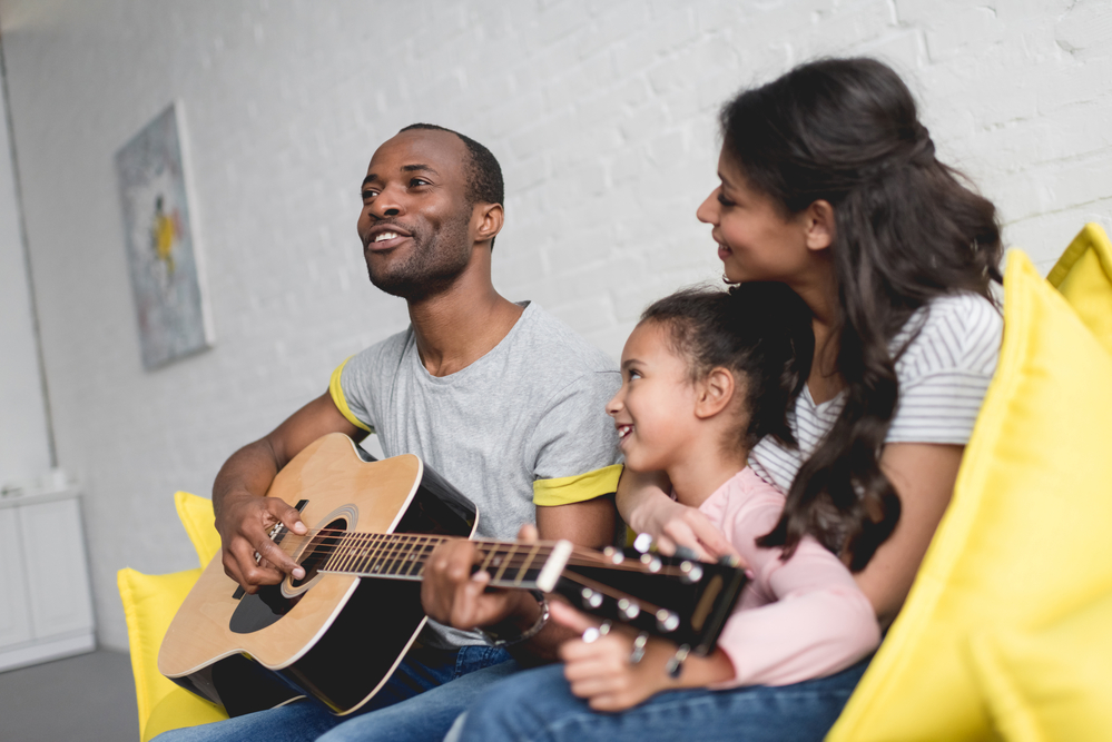 Parents using music to teach letters to  daughter