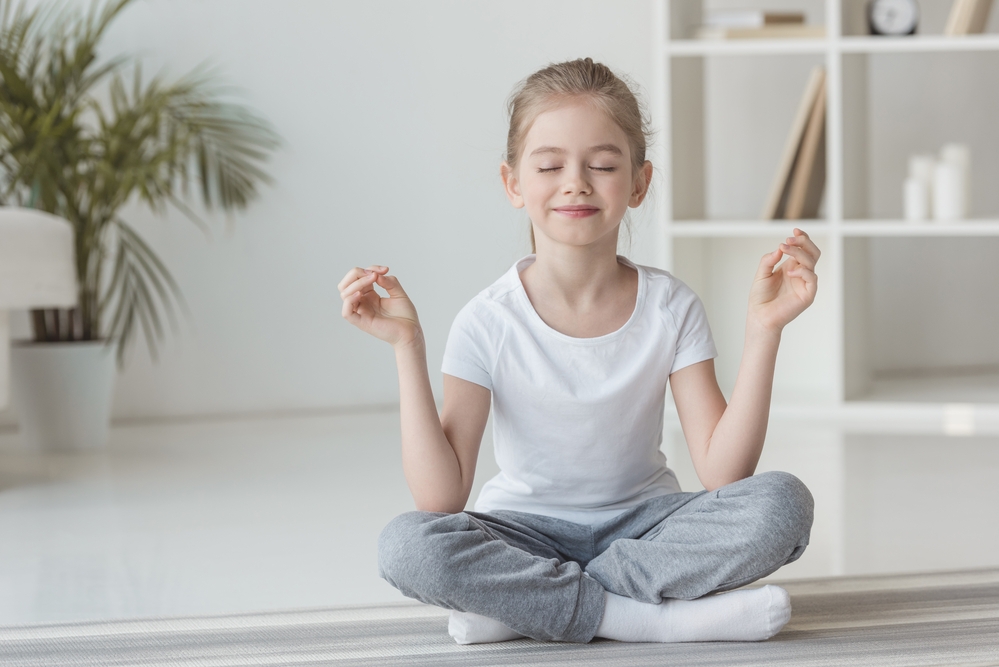 Young girl doing meditation for kids
