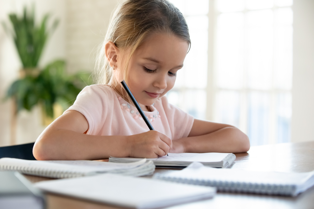 Young girl writing ordinal numbers for kids