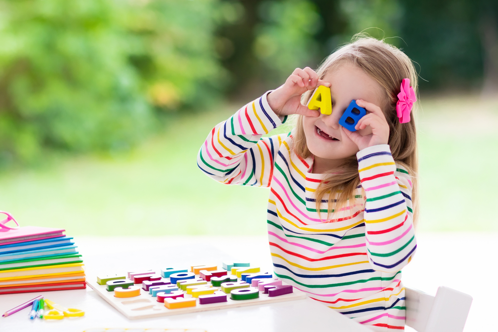 Young girl playing with wood letters