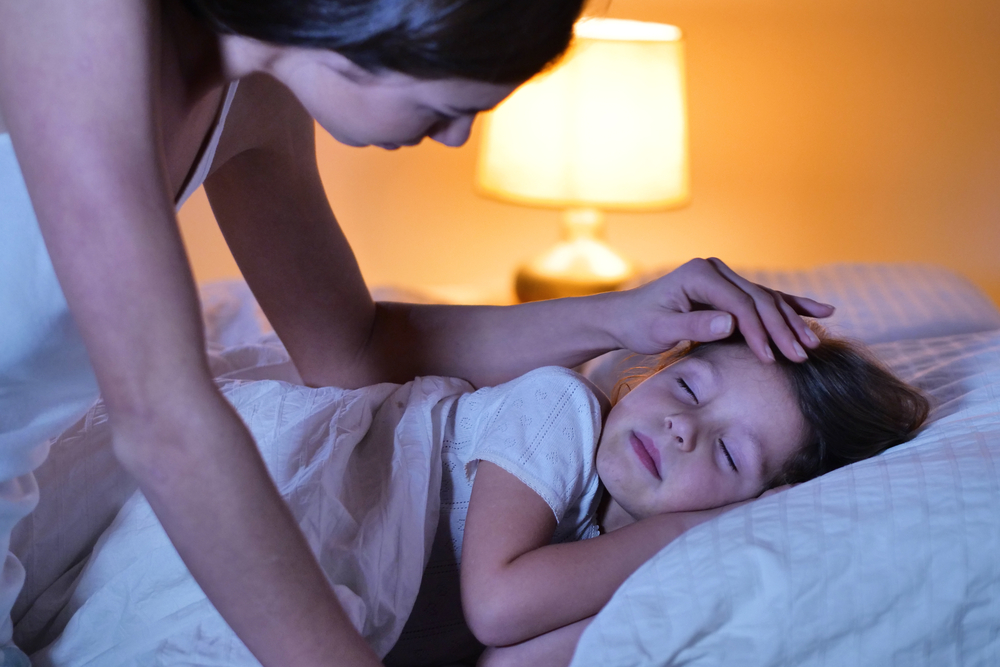 Mom putting daughter to sleep